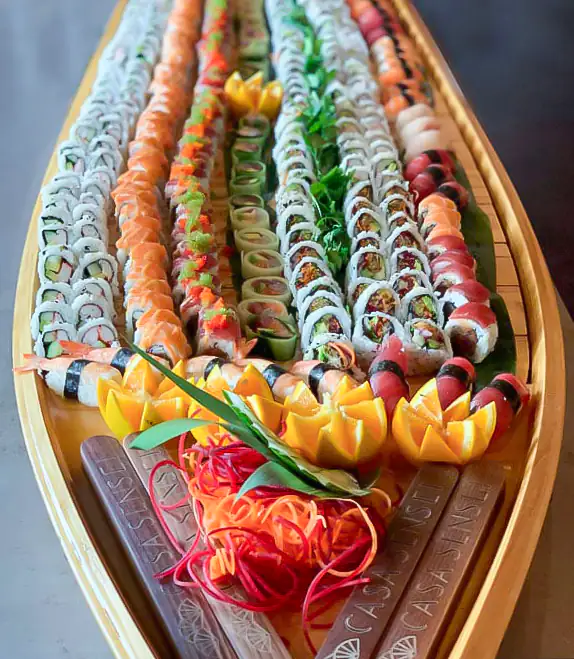 Large wooden sushi boat filled with an abundant assortment of premium sushi rolls and nigiri — Casa Sensei, Fort Lauderdale