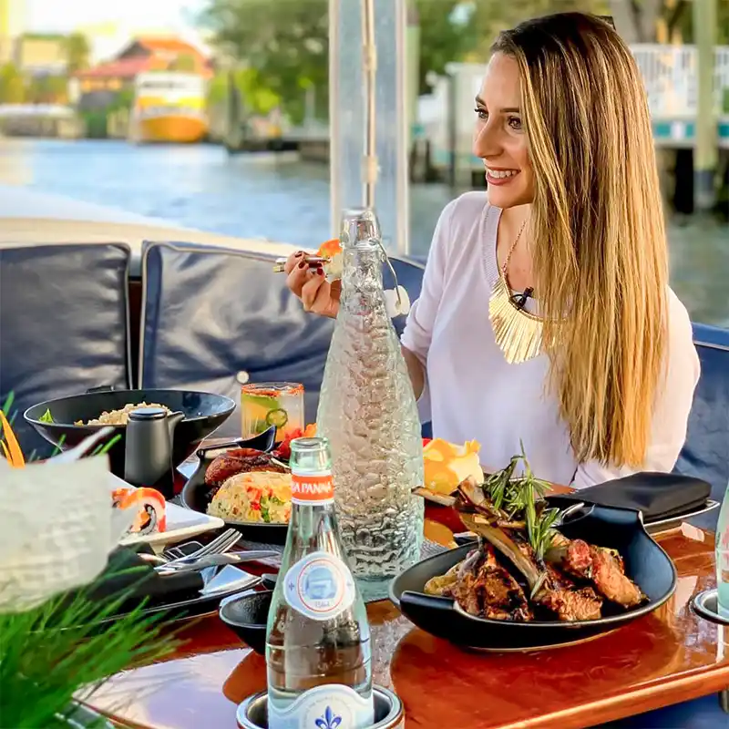 Guest dining on a gondola enjoying Pan-Asian & Latin Fusion dishes including lamb chops and sushi, with scenic river views — Casa Sensei, Fort Lauderdale